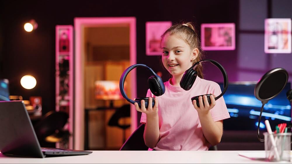 Young girl holding headphones in a room with studio equipment